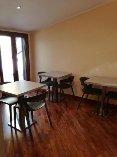 two tables and chairs in a room with wooden floors at Fonte Nuova Penne in Penne