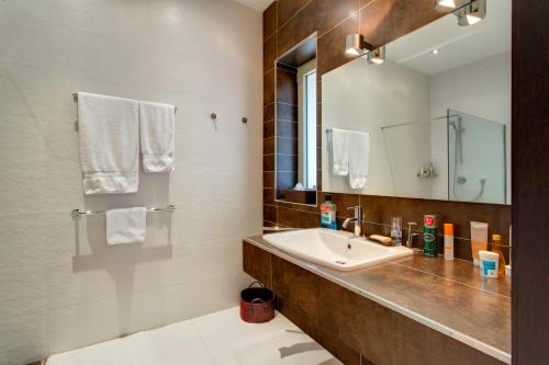 ein Badezimmer mit Waschbecken und Spiegel in der Unterkunft Marvellous Apartment in Tigne Point in Sliema