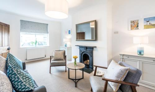 a living room with a fireplace and chairs at Lobster Cottage Lytham in Lytham St Annes