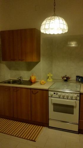 a kitchen with a stove and a sink and a light at Villa Laura Apartment in Giardini Naxos