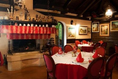 a dining room with tables and chairs and a fireplace at Hotel Makin in Novigrad Istria