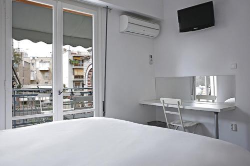 アテネにあるAcropolis apt with balcony - DM17の白いベッドルーム(大型ベッド1台、窓付)