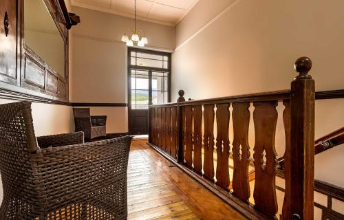 a room with a staircase with a chair and a window at Clanwilliam Hotel in Clanwilliam