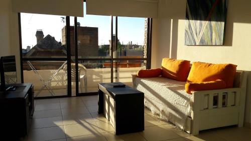 a living room with a couch and a large window at Apartamento Plaza San Martin in Concepción del Uruguay