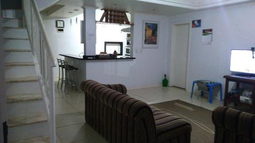 a living room with a couch and a television at Pousada Fritz & Frida in Santa Cruz do Sul