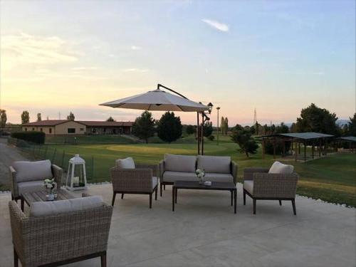 a patio with chairs and a table and an umbrella at Tenuta Lamborghini Golf & Resort in Panicale