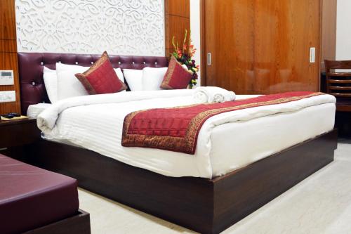 a bedroom with a large bed with red and white pillows at Trinity Corporate Udyog Vihar in Gurgaon