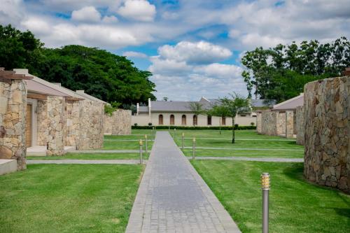 a walkway in front of a building with grass at Africanos Country Estate in Addo