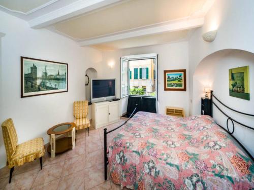 een slaapkamer met een bed en een televisie. bij Garibaldi Flexyrent Apartment in Rapallo
