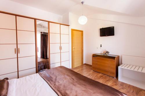 a bedroom with a bed and a dresser and a tv at Villa Roza Murter in Murter