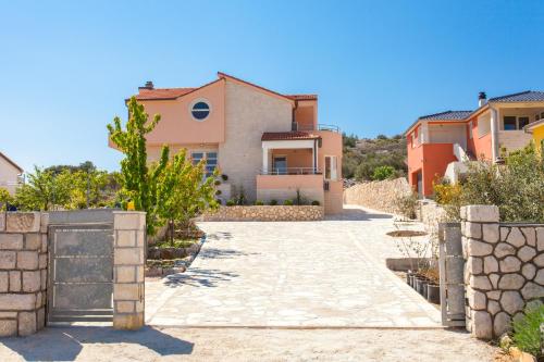 a villa with a driveway in front of a house at Villa Roza Murter in Murter
