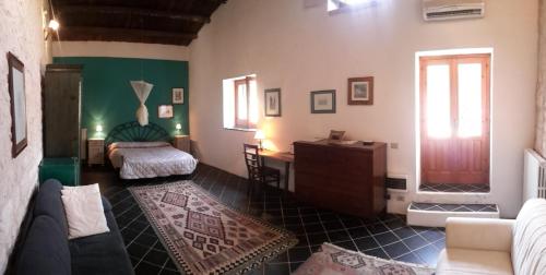 a living room with a couch and a bed at Case Brizza in Casale Zappulla