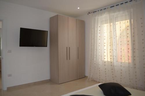 a bedroom with a cabinet and a television on a wall at Casa Low Cost in Tuglie