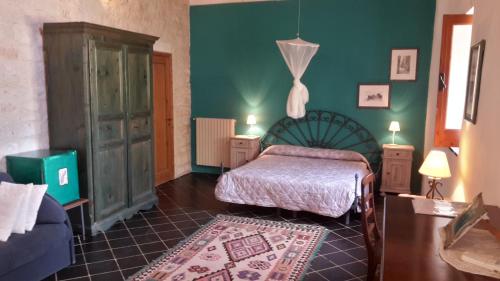 a bedroom with two beds and a green wall at Case Brizza in Casale Zappulla