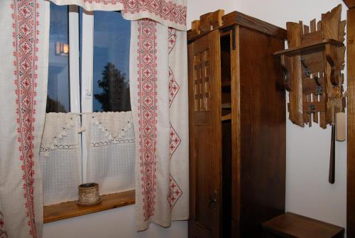 a window with a curtain and a wooden cabinet at Туристично розважальний комплекс "Стіжок" in Berehomet