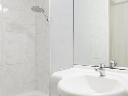 ein weißes Bad mit einem Waschbecken und einer Dusche in der Unterkunft B&B HOTEL Nancy Frouard in Frouard