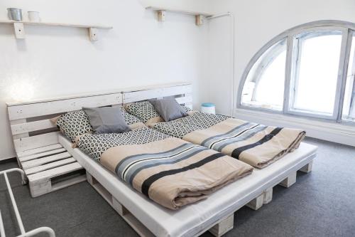 Una cama grande en una habitación con una ventana grande. en Junior Tower Apartment, en Budapest