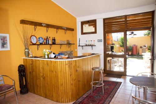 uma cozinha com um bar de madeira num quarto em Apartment Rose e Fiori Sardegna em San Vito