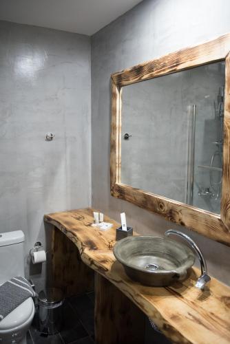 a bathroom with a wooden sink and a mirror at Archontiko Liamas in Stavros