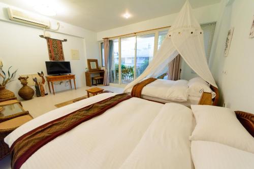 1 Schlafzimmer mit 2 Betten und einem TV in der Unterkunft Bali House in Hualien