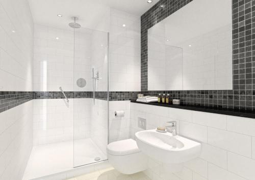 a bathroom with a sink, mirror, and bathtub at Marlin Waterloo in London