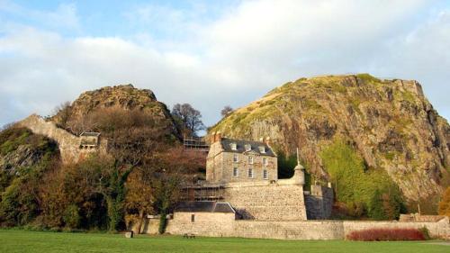 a castle on top of a mountain in a field at Whiteley's Cottages in Dumbarton