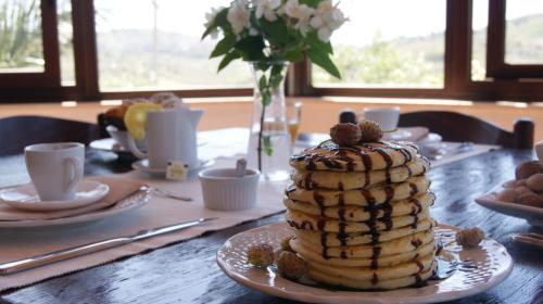 a table with a stack of pancakes on a plate at B&B Eyexei Domus in Agrigento
