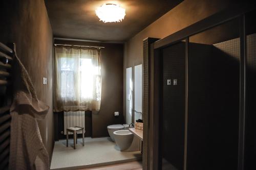 a bathroom with a toilet and a window at Cevoli Country Resort in Lari