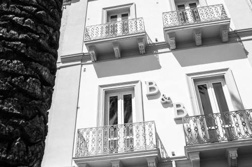 a black and white photo of a building with balconies at Liberty Palace in Milazzo