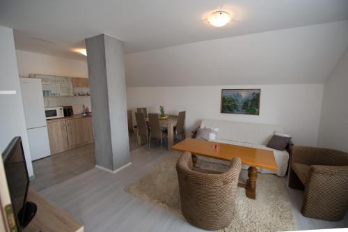 a living room with a table and a kitchen at Apartman Mm in Slavonski Brod