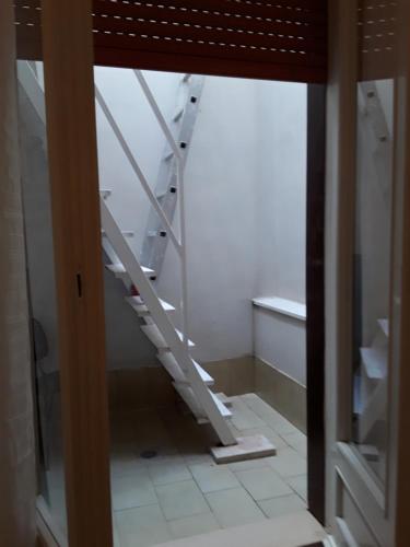 a white staircase in a room with a window at Novecento Dimore di Poesia in Trani