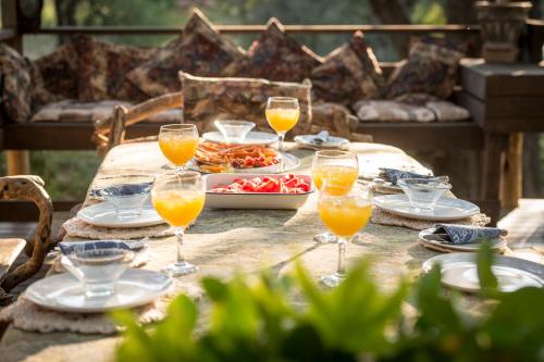 a table with glasses of orange juice and a plate of food at Rio Dos Elefantes River Camp in Hoedspruit