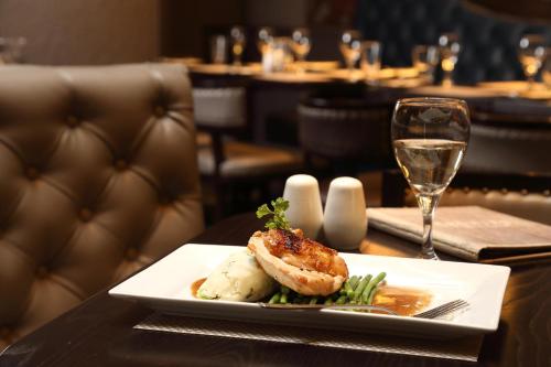 a plate of food on a table with a glass of wine at Golden Lion Hotel in Stirling