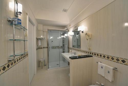 y baño con lavabo, ducha y aseo. en Hotel Belvedere, en Conca dei Marini