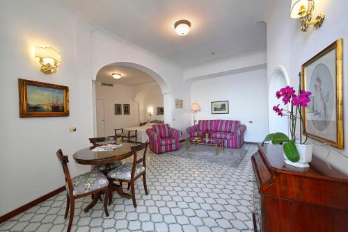 a living room with a table and pink chairs at Hotel Belvedere in Conca dei Marini