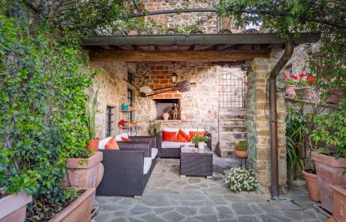 an outdoor patio with wicker furniture and plants at Casale Le Masse in Greve in Chianti