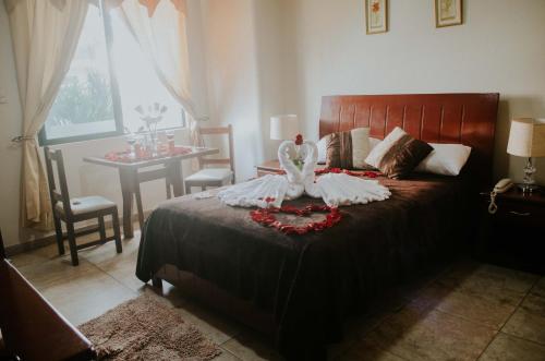 Un dormitorio con una cama y una mesa con una mesa. en Hotel Onix Gold, en Guayaquil