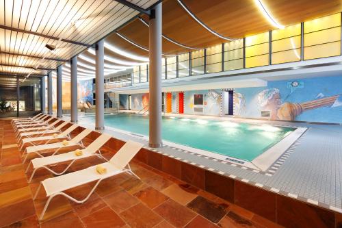 a pool with lounge chairs and a swimming pool at Hapimag Ferienwohnungen Interlaken in Interlaken