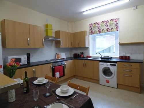 a kitchen with a table and a washing machine at West Lea House in Chesterfield