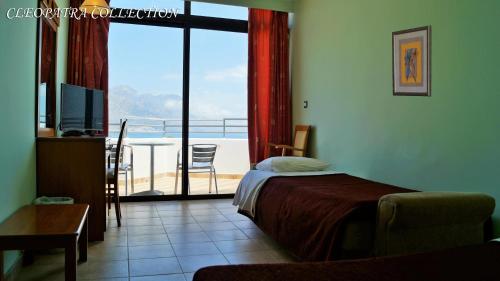 a bedroom with a bed and a view of a balcony at Cleopatra Superior in Kardamaina