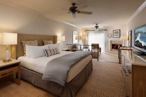 a bedroom with a large bed and a living room at Pelican Inn & Suites in Cambria