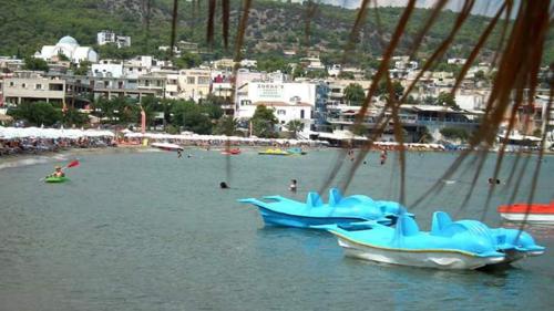two boats sitting in the water near a beach at Artemis Rooms in Agia Marina Aegina