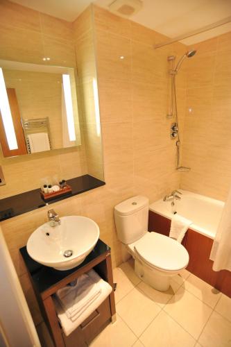 a bathroom with a toilet and a sink and a tub at Golden Lion Hotel in Stirling