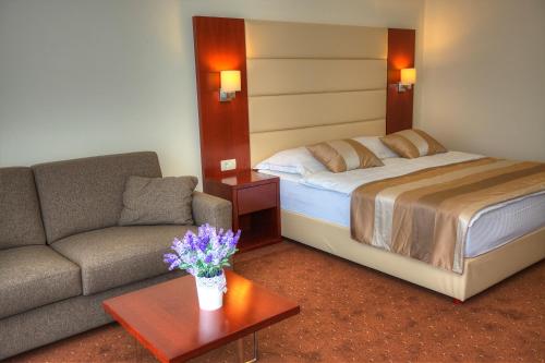 a hotel room with a bed and a couch at Hotel Palace Medjugorje in Međugorje