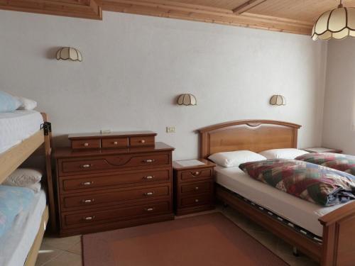 ein Schlafzimmer mit zwei Betten und einer Kommode in der Unterkunft Cesa Fossal in Colle Santa Lucia