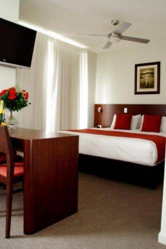 Habitación de hotel con cama y escritorio con mesa en Mary River Motor Inn en Gympie