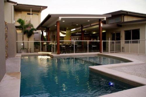 a swimming pool in front of a house at Mary River Motor Inn in Gympie