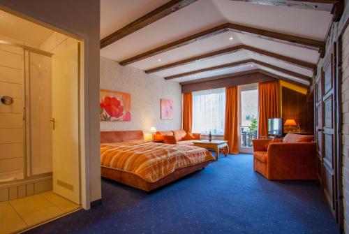 a hotel room with a bed and a couch at Grainauer Hof in Grainau