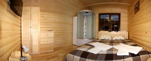 タターリウにあるSadyba Yalivetsの木製の部屋にベッド1台が備わるベッドルーム1室があります。