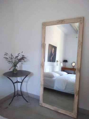 a mirror in a bedroom with a bed and a table at "Le Vent d'Étoile" B&B and Guesthouses in Mormoiron